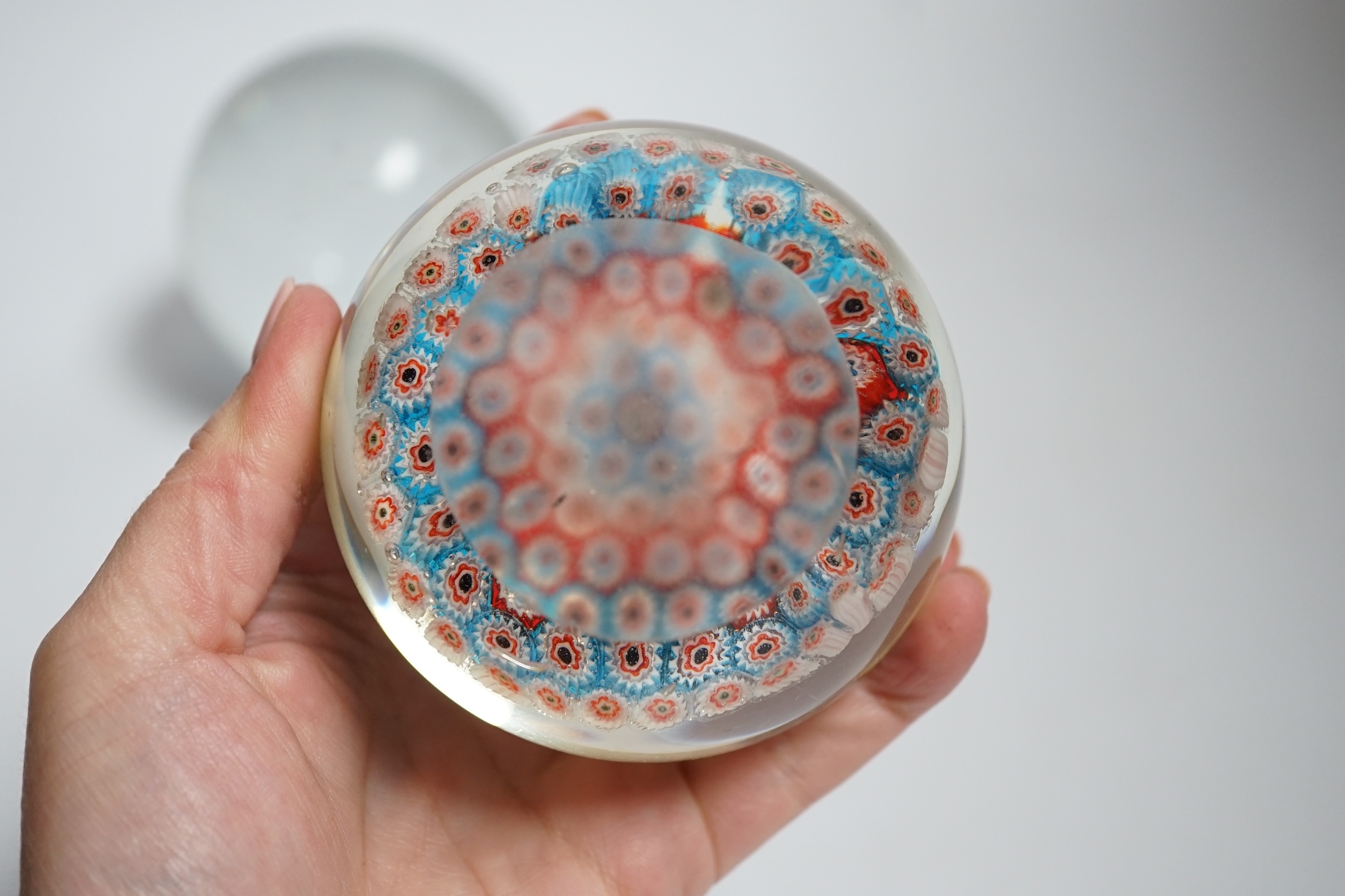 Two millefiori paperweights and a glass ball, largest 10cm in diameter